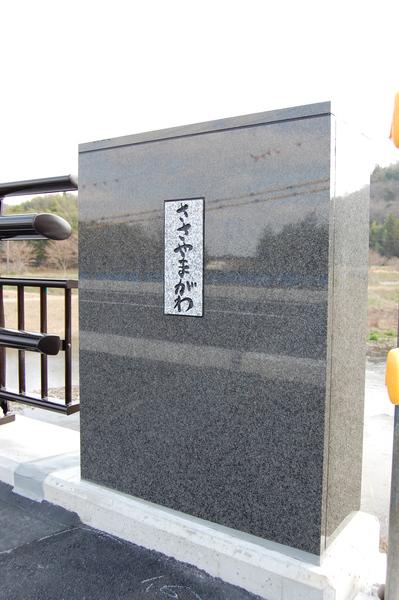 橋の端にある石で作られた親柱にささやまがわと書かれている写真