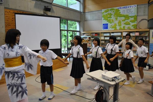 子供達が浴衣を着た女性に踊りを教えてもらっている写真