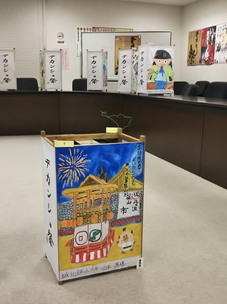 イメージキャラクターと花火のお祭りの絵が描かれた作品の写真