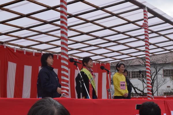 女性3人がスタンドマイクの前に立って、挨拶をしている写真