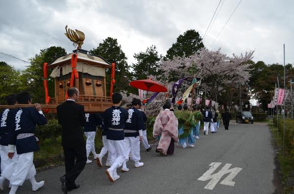 青山神社と書かれた紺の法被を着た人たちが神輿を担いでいる写真