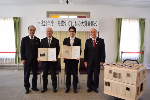 丹波すぐれもの大賞表彰式にて受賞者が賞状の入った額を持って市長らと一緒に記念撮影している写真