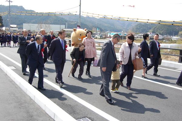 スーツを着た男性達や、小学生たちが橋を歩いている写真