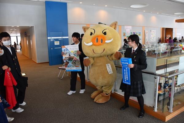 ゆるキャラを真ん中に男子学生と女子学生がユニセフ支援を呼びかけている写真