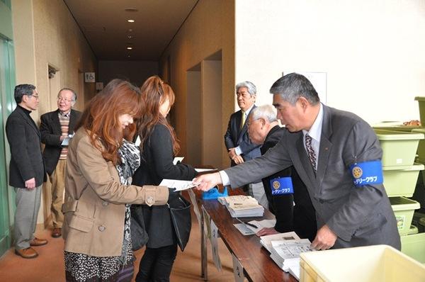 篠山ロータリークラブの方が参加者の女性に紙を手渡している写真