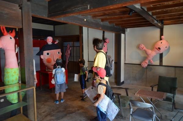 大きな手作りの人形の前で2人の子供が見ている写真