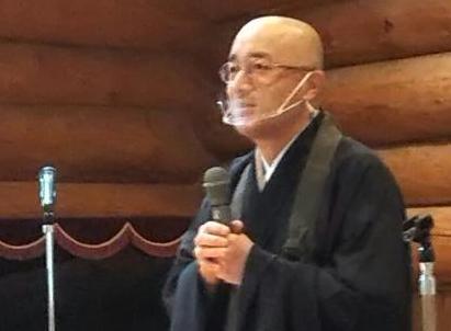 安達住職がマイクを両手で持ってお話をされている