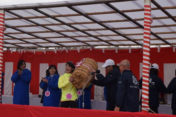 有森 裕子さんが俵を受け取って、横の方が拍手する写真