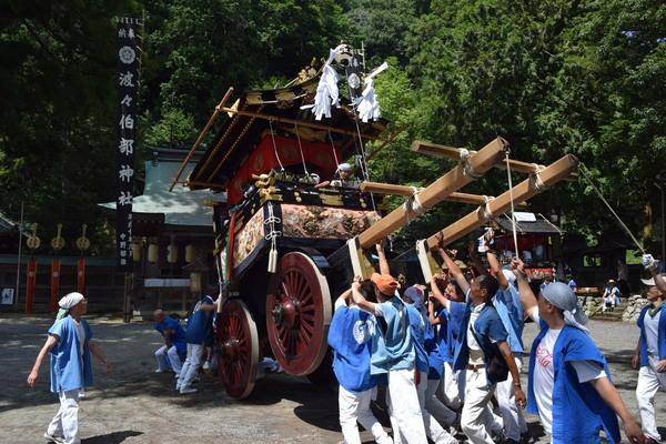 10人ほどの人達が山車を持ち上げていて、片方の車輪が上にあがっている写真