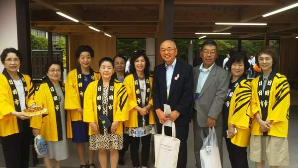 黄色の法被を着ている日田市の地域の皆さんと市長との記念写真