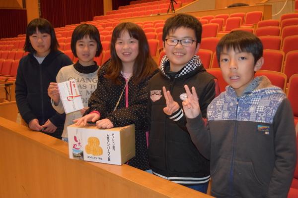 「人気ナンバーワン賞」を受賞した西紀小学校の男女5名の生徒が目録や副賞を持ってピースサインで記念撮影している写真