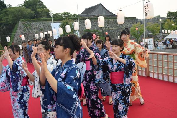 オレンジや紺の色の浴衣を着た女性が踊っている写真