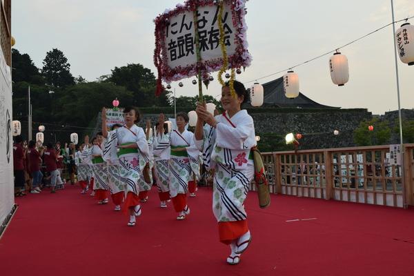 「たんなん音頭保存会」のプラカードを持った女性たちが踊っている写真