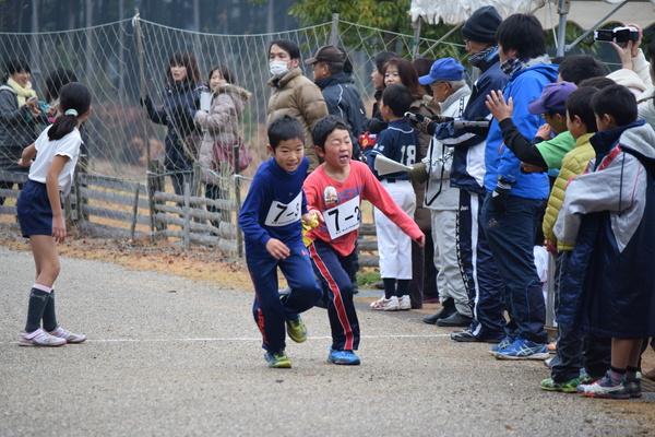 走って来た男子生徒が次の走者に襷を渡す瞬間の写真