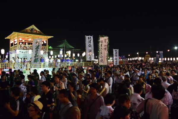 夜のお祭りにたくさん人が来て歩いている写真