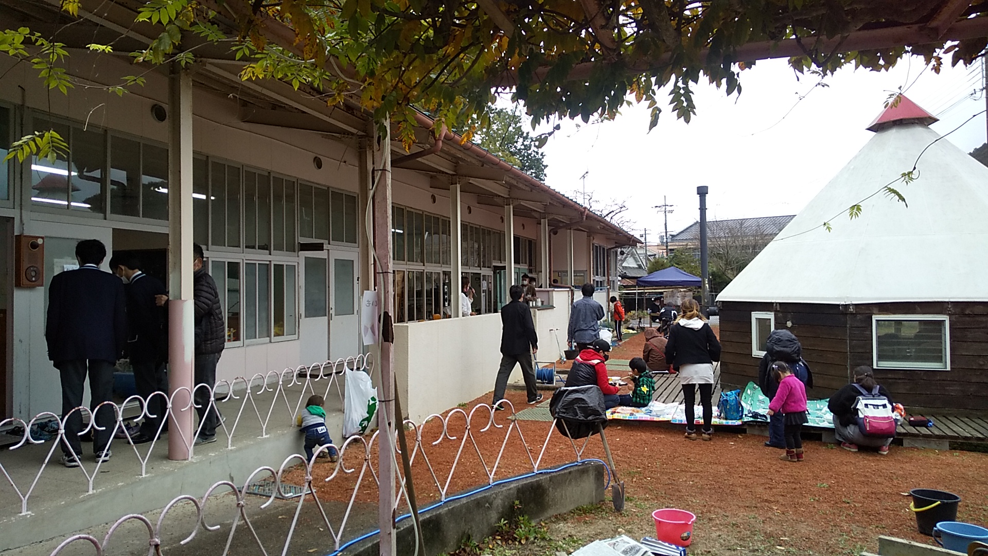 パオのまわりに座って豚汁を食べる来場者