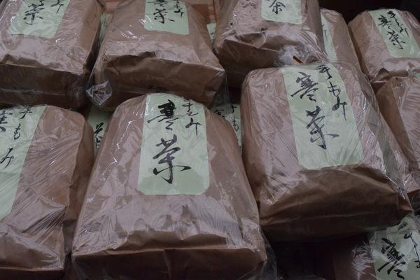 袋に入れられ「手もみ寒茶」と書かれたラベルが張ってある寒茶が山積みに並べられている写真