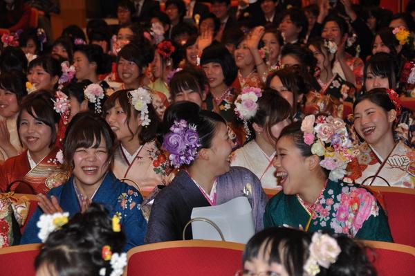 客席に座って笑顔があふれている、振袖を着た新成人達の写真