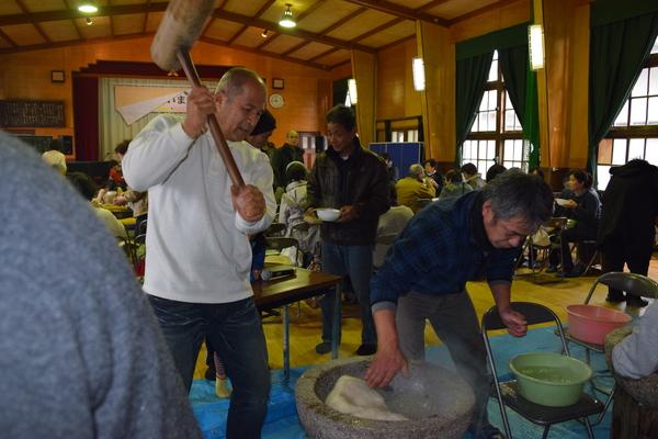 男性2人が杵と臼での昔ながらのもちつきをしている写真