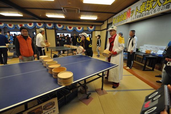 白い帽子を被った男女ペアの参加者が桶で卓球をしている写真