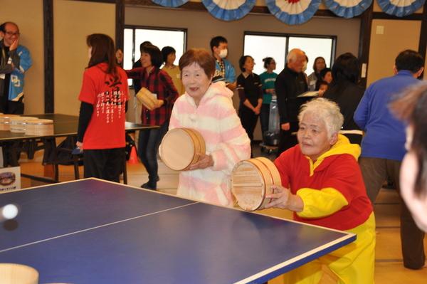 着ぐるみパジャマを着た女性二人の参加者が桶を持って卓球をしている写真