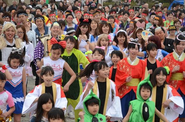 様々なコスチュームや法被を着た市民の間に紛れた市長と議長が総踊りに一緒に参加している写真