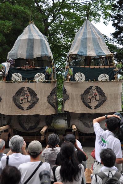 展示している大きな山車2台を祭りを見に来られた観客が写真を撮っている写真
