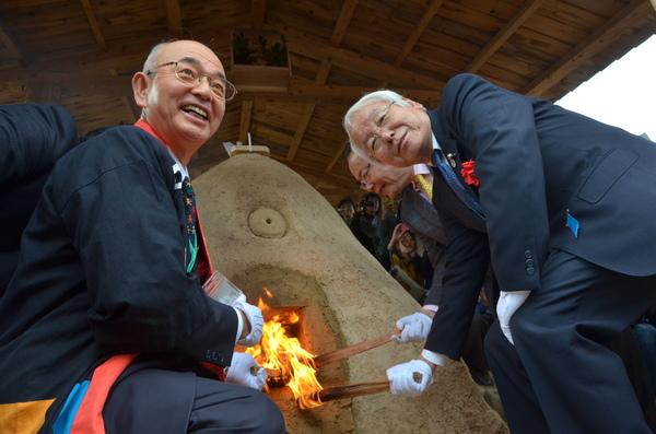 市長と男性達が窯に火を入れている写真