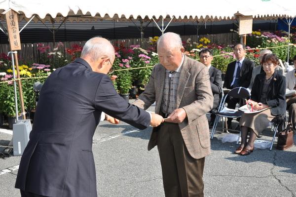 篠山市長賞の稲山 寅夫さんが、賞状を受け取っている写真