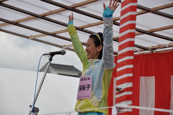 ゲストランナー有森 裕子さんが舞台から選手たちに手を振っている写真
