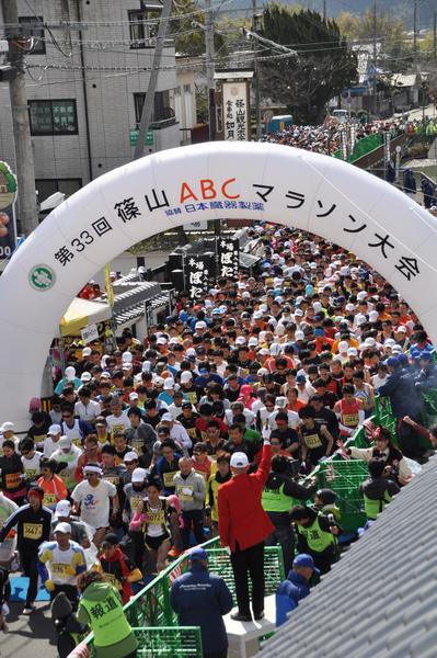 市長が高い位置から「よーいドン」とピストルを鳴らし選手たちが一斉にスタートしている写真