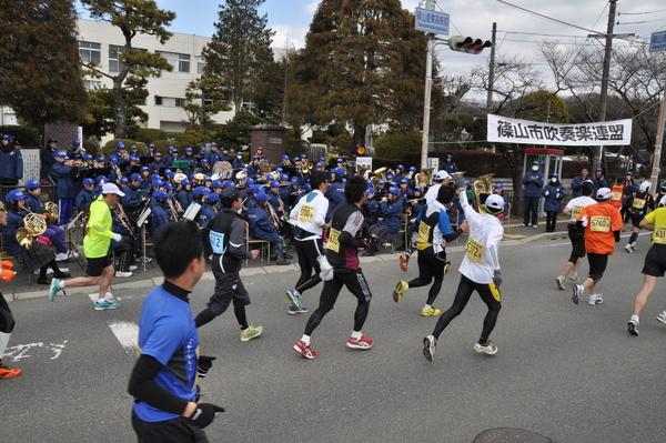 選手が走っている中、篠山市吹奏楽部の皆さんが応援で楽器を演奏している写真