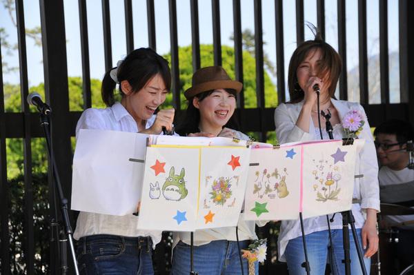 トトロの絵が描かれている楽譜を楽譜台に置き、笑顔で写っている3名の女性の写真