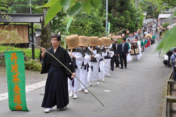 虚無僧が天蓋を被り尺八を吹いている行列を先頭にお茶壺道中の行列が遠くまで続いている様子を写している写真