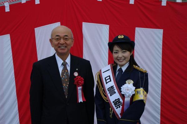 紅白の幕の前で、1日警察署長の熊谷 奈美さんと市長が笑顔で写っている写真