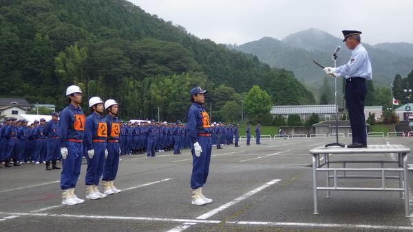 背番号を付けた団員の方が1名代表で表彰を受けその後ろに3名の団員の方が立っている写真