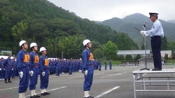 ヘルメット被った団員の方が代表で表彰を受けてその後ろに3名の団員が立っている写真