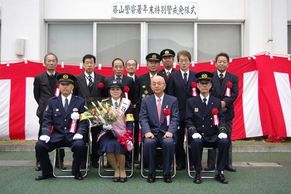 花束を持っている一日警察署長の瀬頭 とよみさんと市長と篠山警察署年末警戒発隊式に参加された方々の記念写真