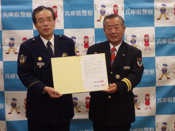 篠山警察署長と消防団長が締結書類を持って記念撮影している写真