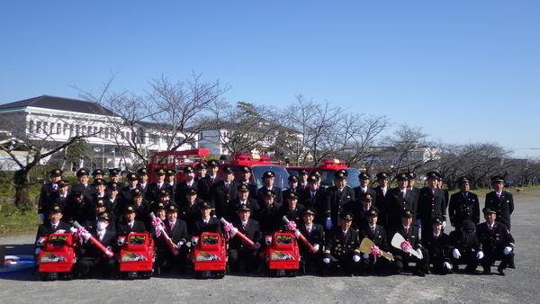 消防団員が引渡された消防車2台と小型動力ポンプ4台と一緒に写っている記念写真