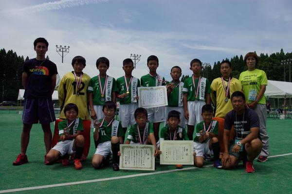 首にメダルをかけた12人の部員たちと3名の大人が並んでいる集合写真