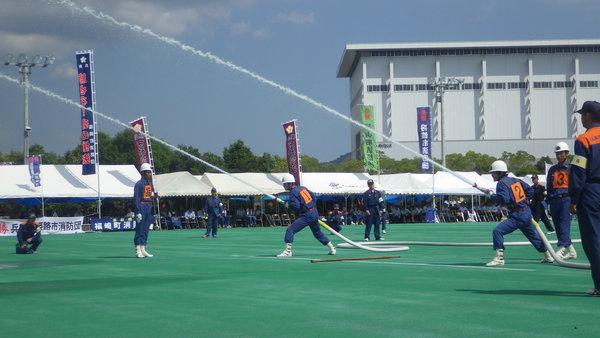 消防団員二人がそれぞれホースを構え、二人のホースから水が噴き出している様子の訓練の写真