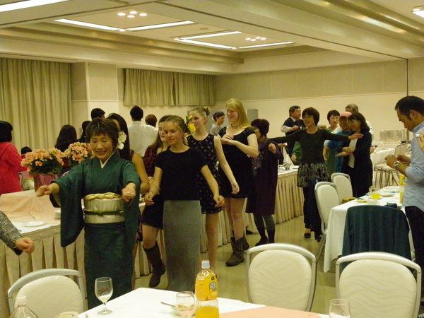 着物を着た女性の後に留学生たち並びデカンショ踊りを踊っている写真