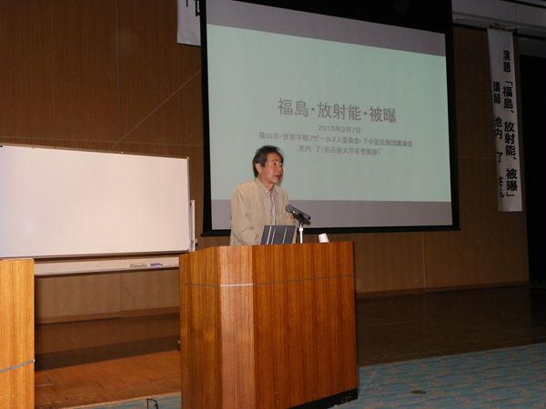 プロジェクトスクリーンの前で話す、地球物理学の池内 了先生の写真