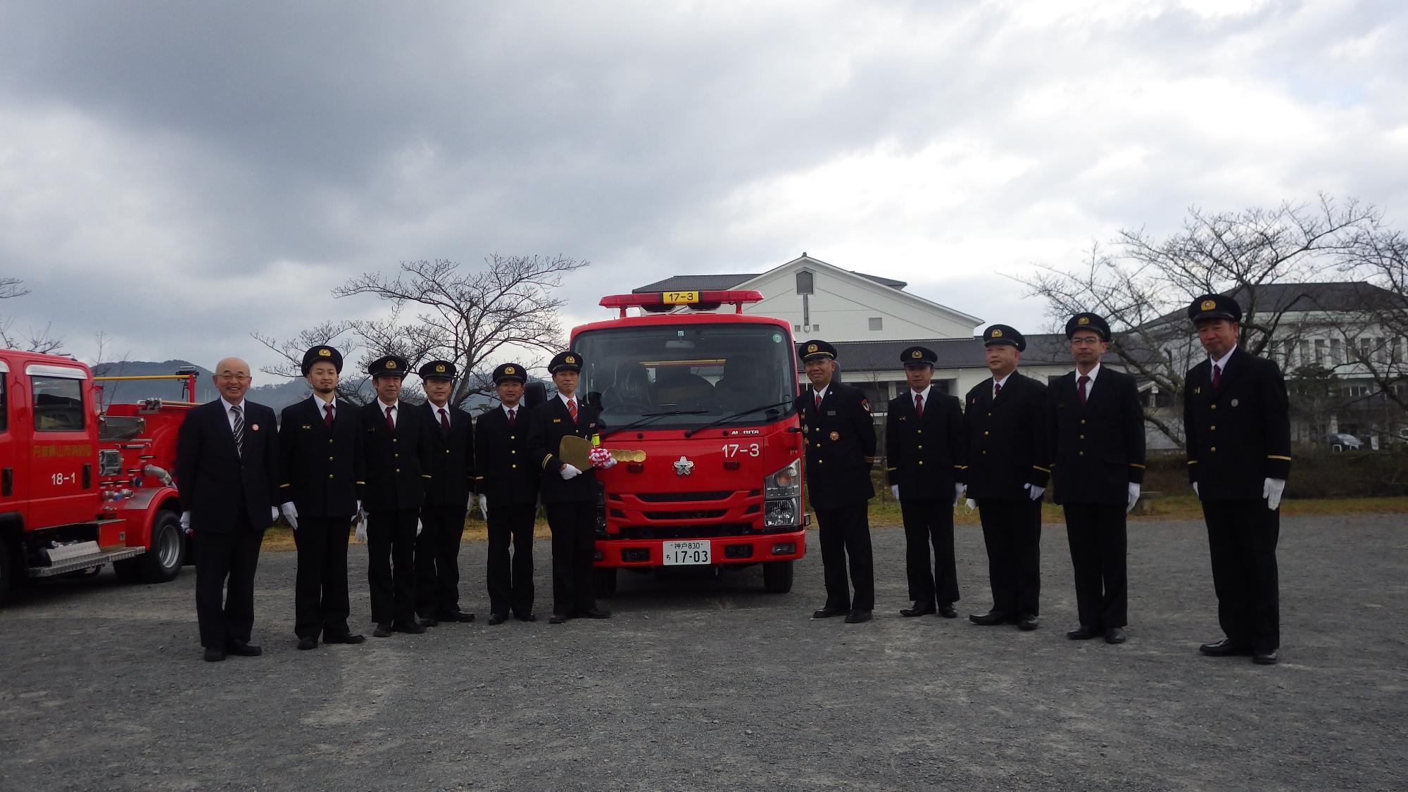 新しい車両を囲んで酒井市長と消防団員が記念撮影