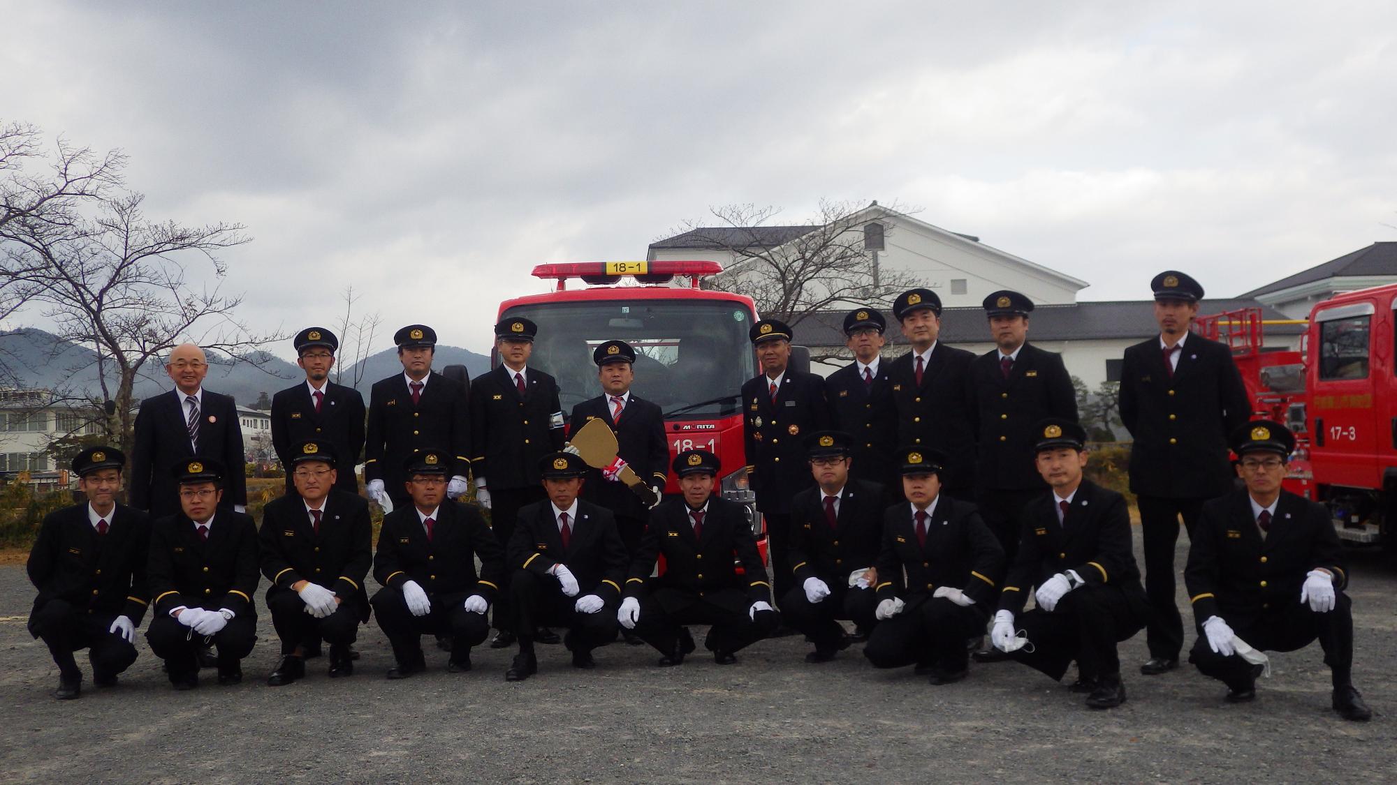 新しい車両の前で酒井市長と消防団員が記念撮影