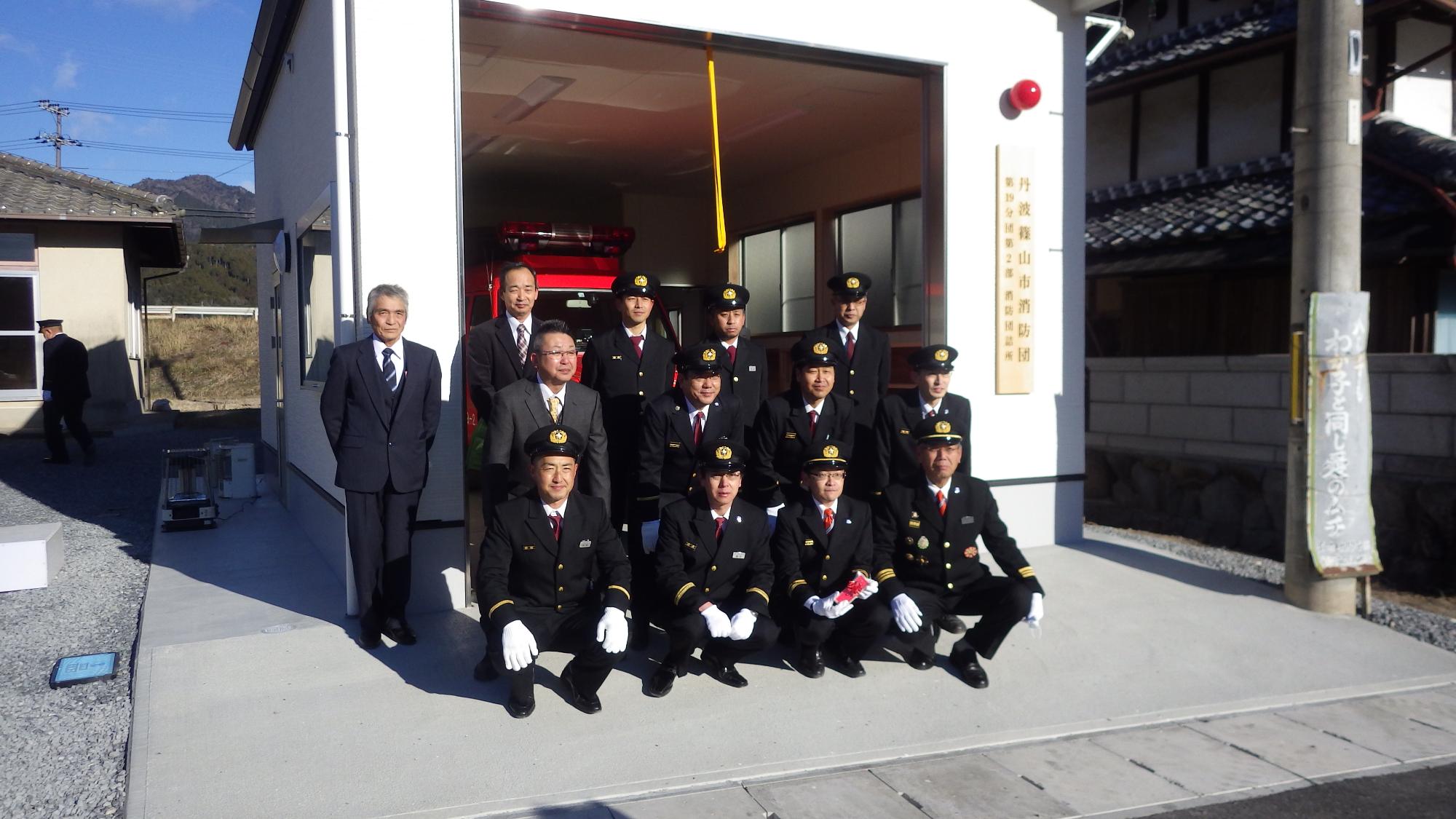完成した詰所の前で記念撮影する消防団員