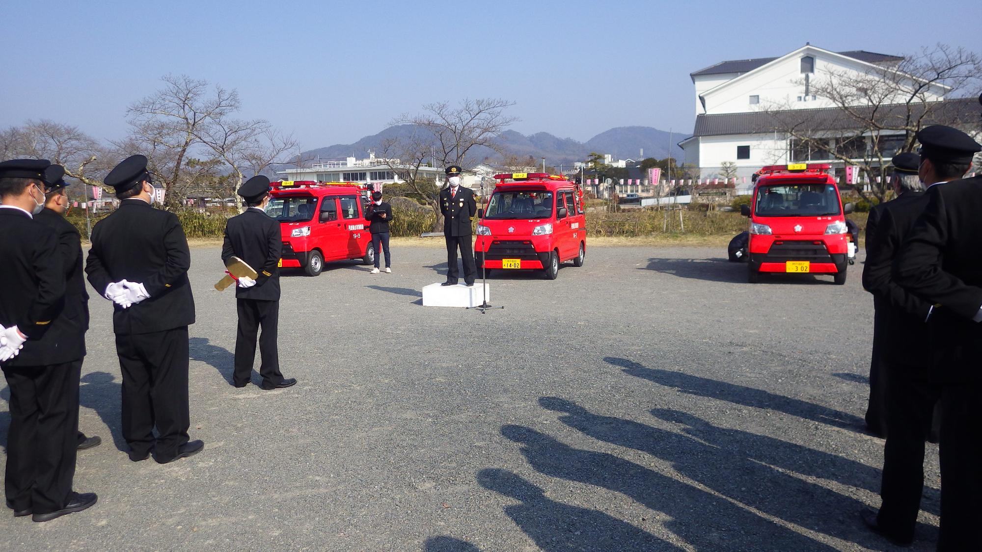 新しい消防車両3台の前で、消防団の方が挨拶されている