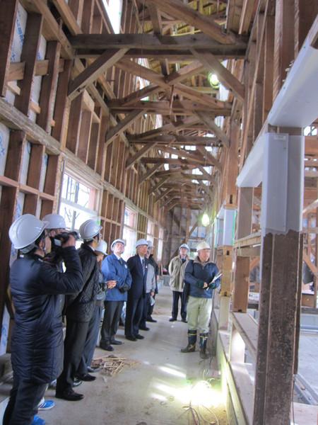 木組みの建物の中をヘルメットを着けて、見物している男性たちの写真