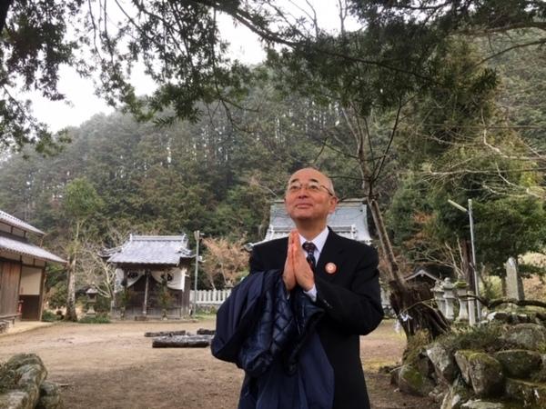 市長が神社の庭で、新年の抱負を思いながら、空に向かって手を合わせている様子の写真